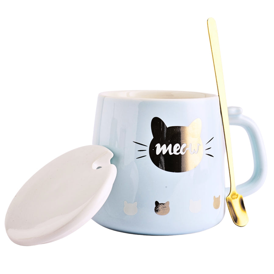 A ceramic mug with a cute cartoon cat printed on the side. The mug is a light blue color and has a white ceramic lid with a small handle on top. A golden spoon sits beside the mug.