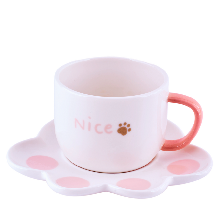 A pastel ceramic mug with a white cat paw shaped saucer beside it. The mug has a smooth finish and appears delicate.