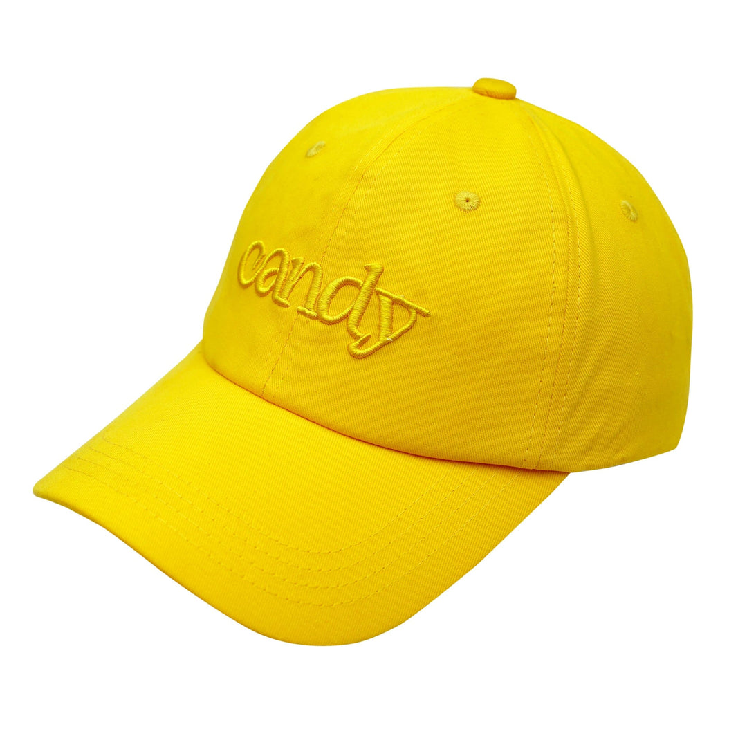 A yellow cotton baseball cap with a curved brim and an adjustable strap in the back. The cap has the word "Candy" embroidered on the front in a yellow thread, with a slight 3D puff to the lettering.