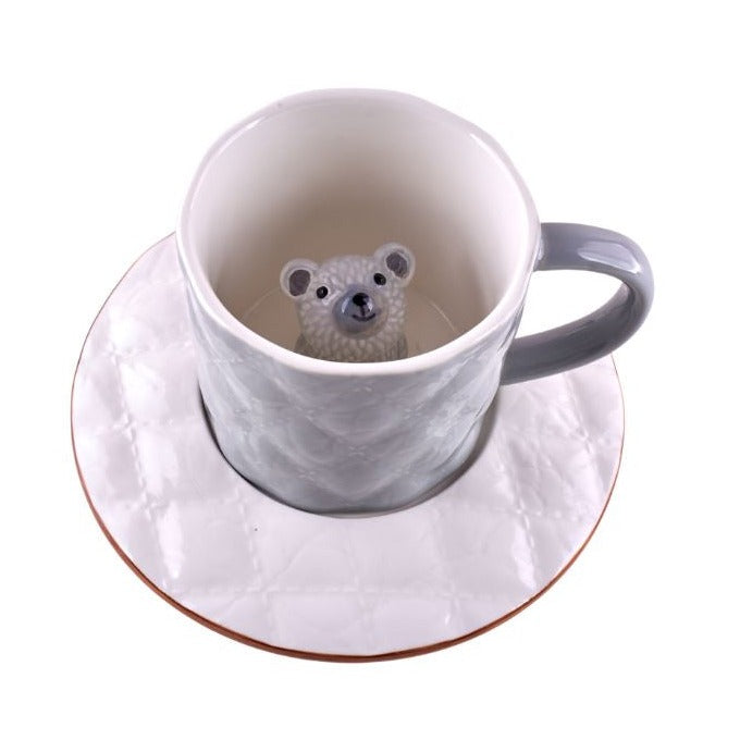 A grey ceramic mug with a white cartoon bear peeking out from the bottom. The mug has a textured finish and appears adorable.